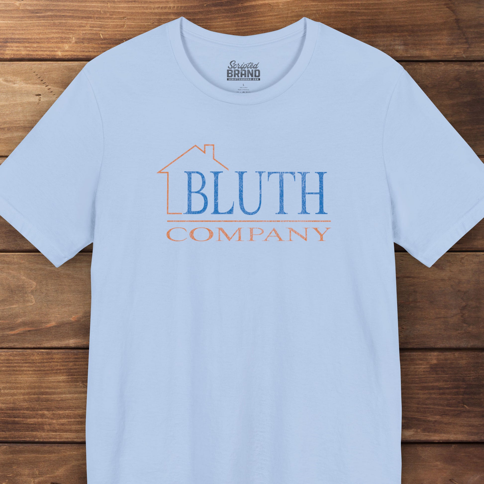 Front view of baby blue Bella+Canvas t-shirt featuring a vintage Bluth Company logo inspired by the TV show Arrested Development.