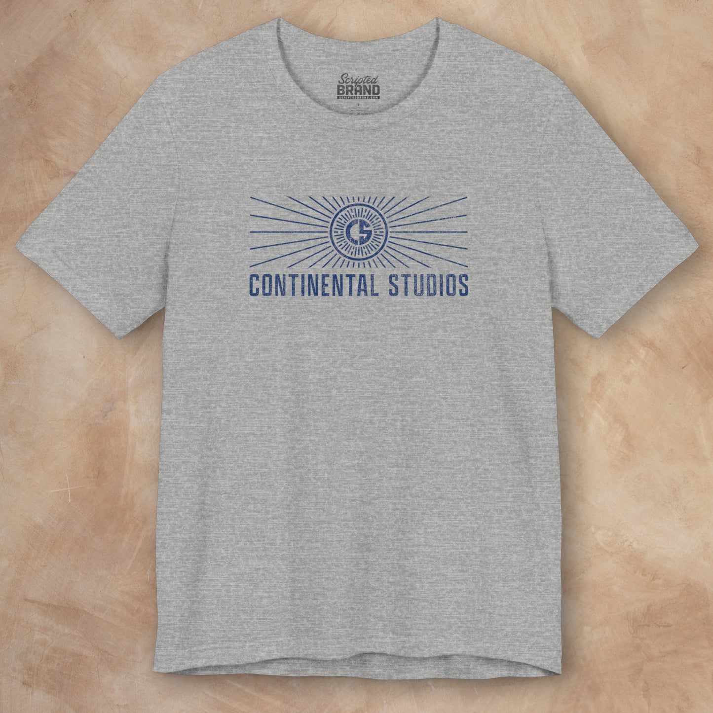 Front view of an athletic heather gray colored Soft Bella+Canvas 3001 short-sleeve t-shirt featuring the logo graphic of the fictional movie studio Continental Studios inspired by the Apple TV show The Studio in a vintage distressed style, sold by ScriptedBrand.