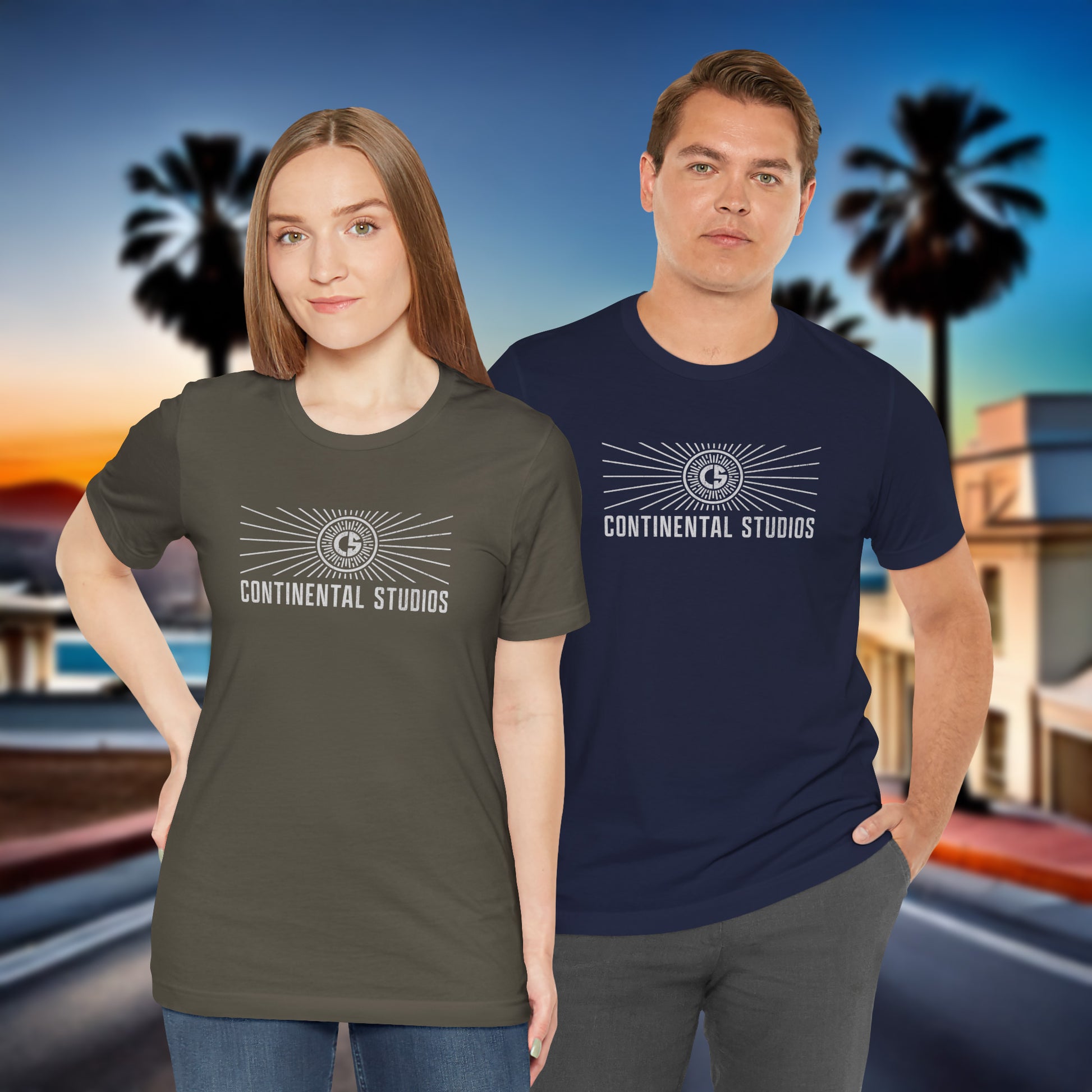 2 models wearing army and navy colored Soft Bella+Canvas 3001 short-sleeve t-shirts featuring the logo graphic of the fictional movie studio Continental Studios inspired by the Apple TV show The Studio in a vintage distressed style, sold by ScriptedBrand.