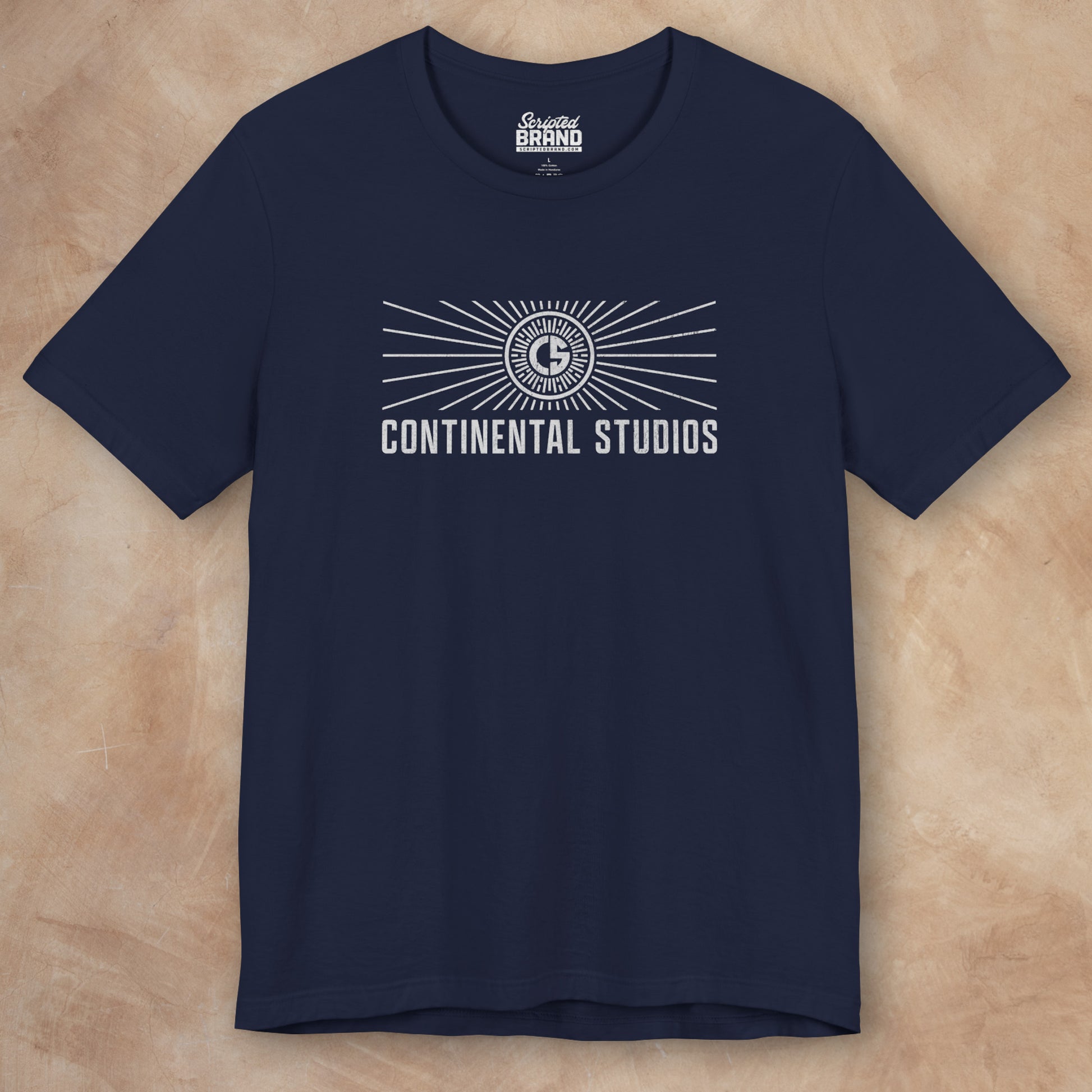 Front view of a navy colored Soft Bella+Canvas 3001 short-sleeve t-shirt featuring the logo graphic of the fictional movie studio Continental Studios inspired by the Apple TV show The Studio in a vintage distressed style, sold by ScriptedBrand.