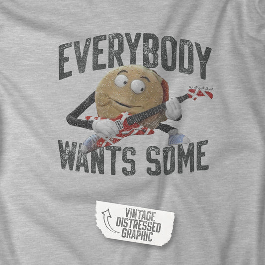 Closeup view of an athletic heather grey colored soft Bella+Canvas 3001 short-sleeve t-shirt featuring the phrase EVERYBODY WANTS SOME with a graphic of the Van Halen singing hamburger playing guitar from the movie Better Off Dead, designed by ScriptedBrand in a vintage distressed style.