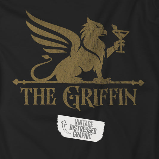 Closeup of black t-shirt featuring gold The Griffin Bar logo inspired by the TV show New Girl in a vintage distressed style.