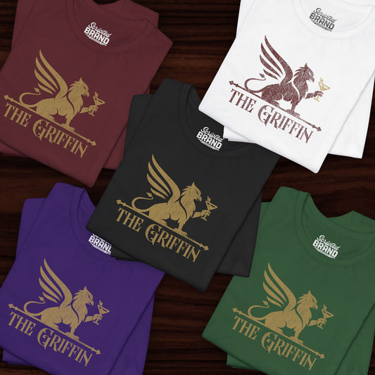 Five folded t-shirts featuring gold The Griffin Bar logo inspired by the TV show New Girl in a vintage distressed style.