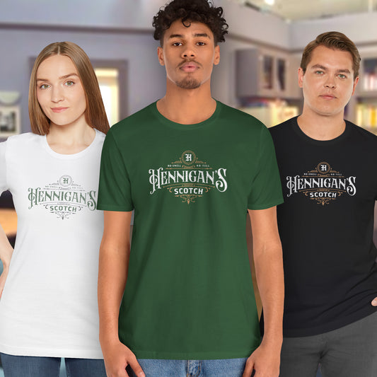 3 models wearing soft short-sleeve t-shirts featuring a Hennigans Scotch Whisky logo graphic inspired by the TV show Seinfeld in a vintage distressed ink-stamped worn-in style.