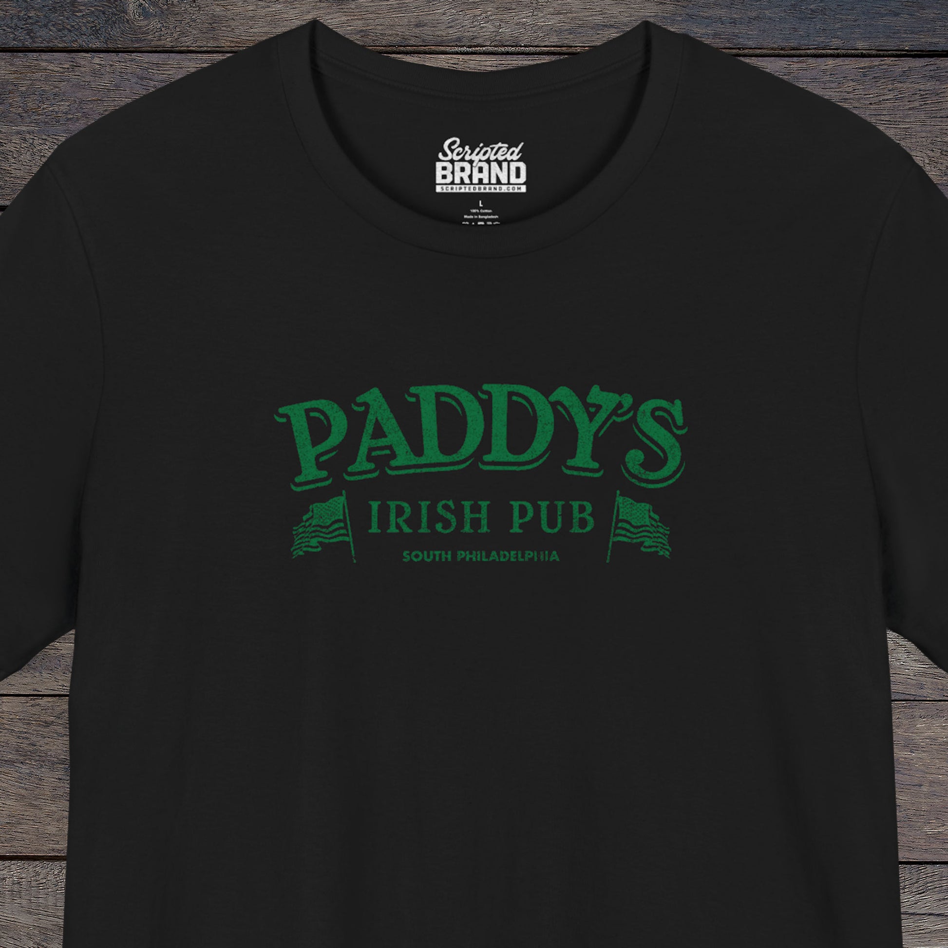 Front view of a black colored soft Bella+Canvas 3001 short-sleeve t-shirt tee featuring the green Paddy's Pub logo from the TV Show It's Always Sunny in Philadelphia, in a vintage distressed style, sold by ScriptedBrand.