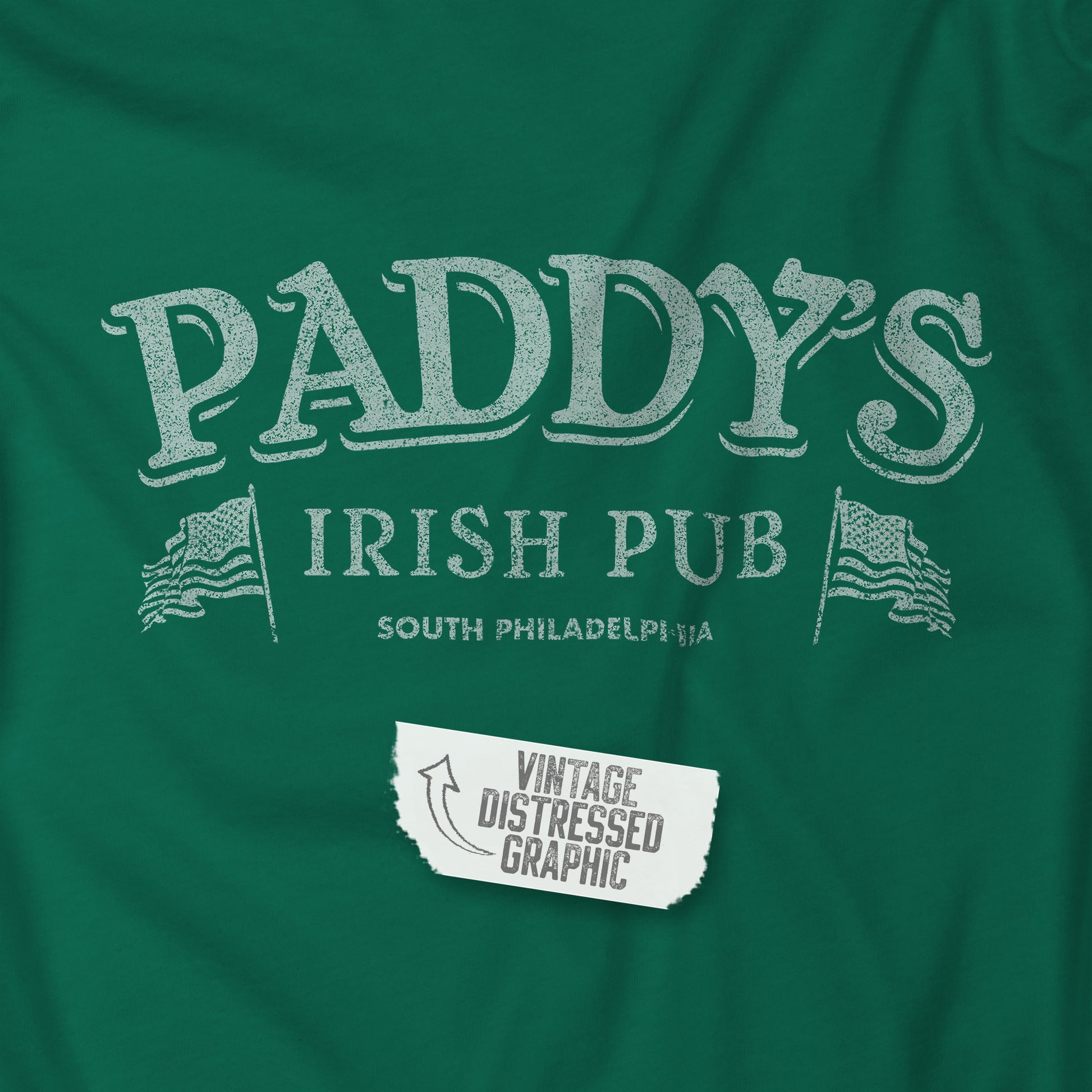 Closeup view of a kelly green colored soft Bella+Canvas 3001 short-sleeve t-shirt tee featuring the Paddy's Pub logo from the TV Show It's Always Sunny in Philadelphia, in a vintage distressed style, sold by ScriptedBrand.