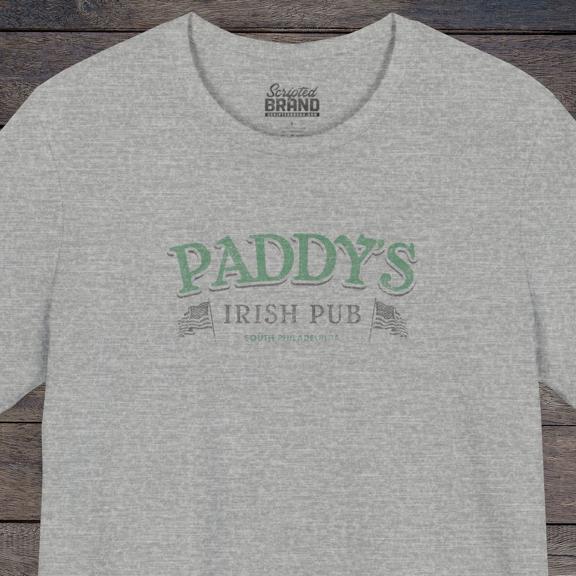Front view of an athletic heather grey colored soft Bella+Canvas 3001 short-sleeve t-shirt tee featuring the green Paddy's Pub logo from the TV Show It's Always Sunny in Philadelphia, in a vintage distressed style, sold by ScriptedBrand.