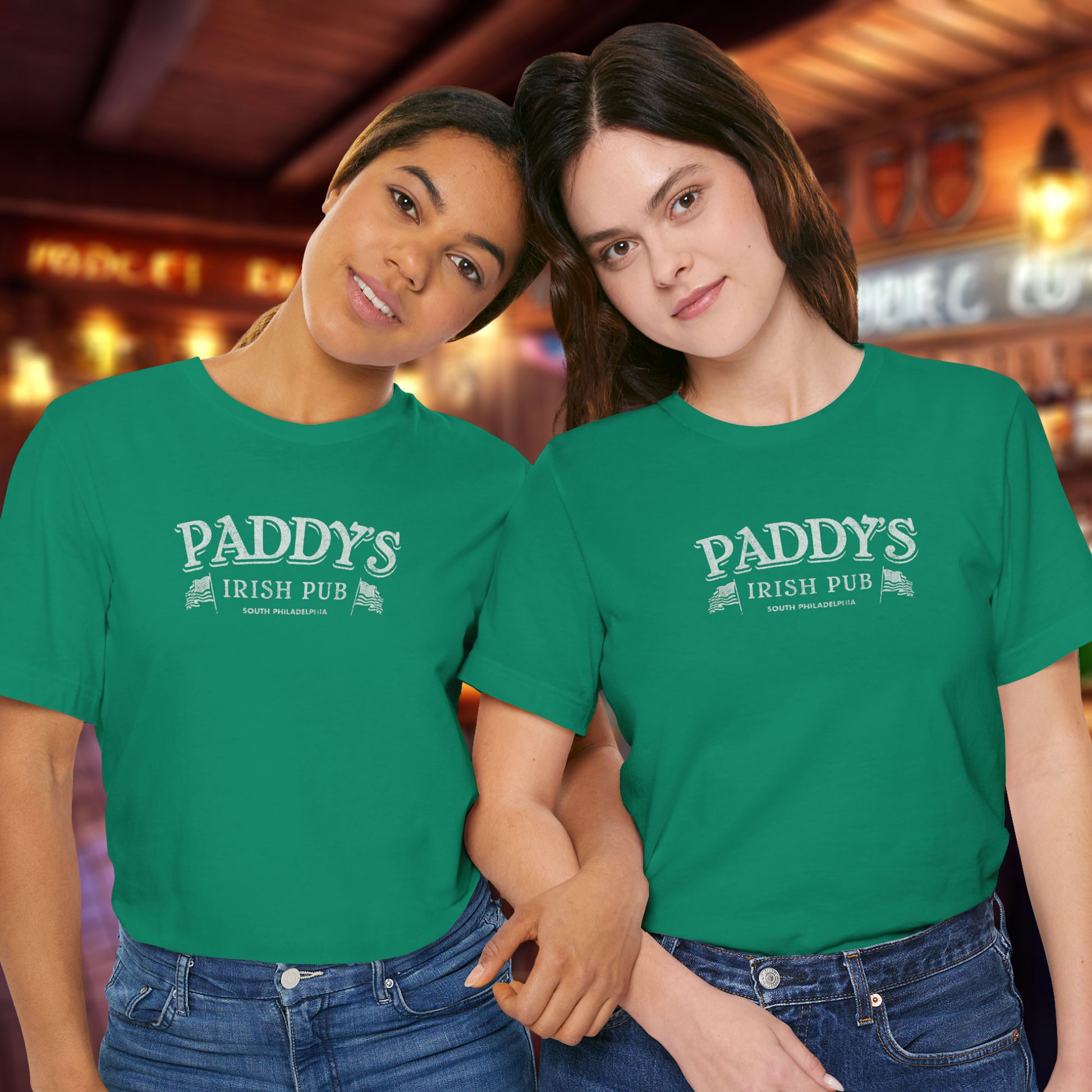 2 female models wearing kelly green colored soft Bella+Canvas 3001 short-sleeve t-shirts featuring the Paddy's Pub logo from the TV Show It's Always Sunny in Philadelphia, in a vintage distressed style, sold by ScriptedBrand.