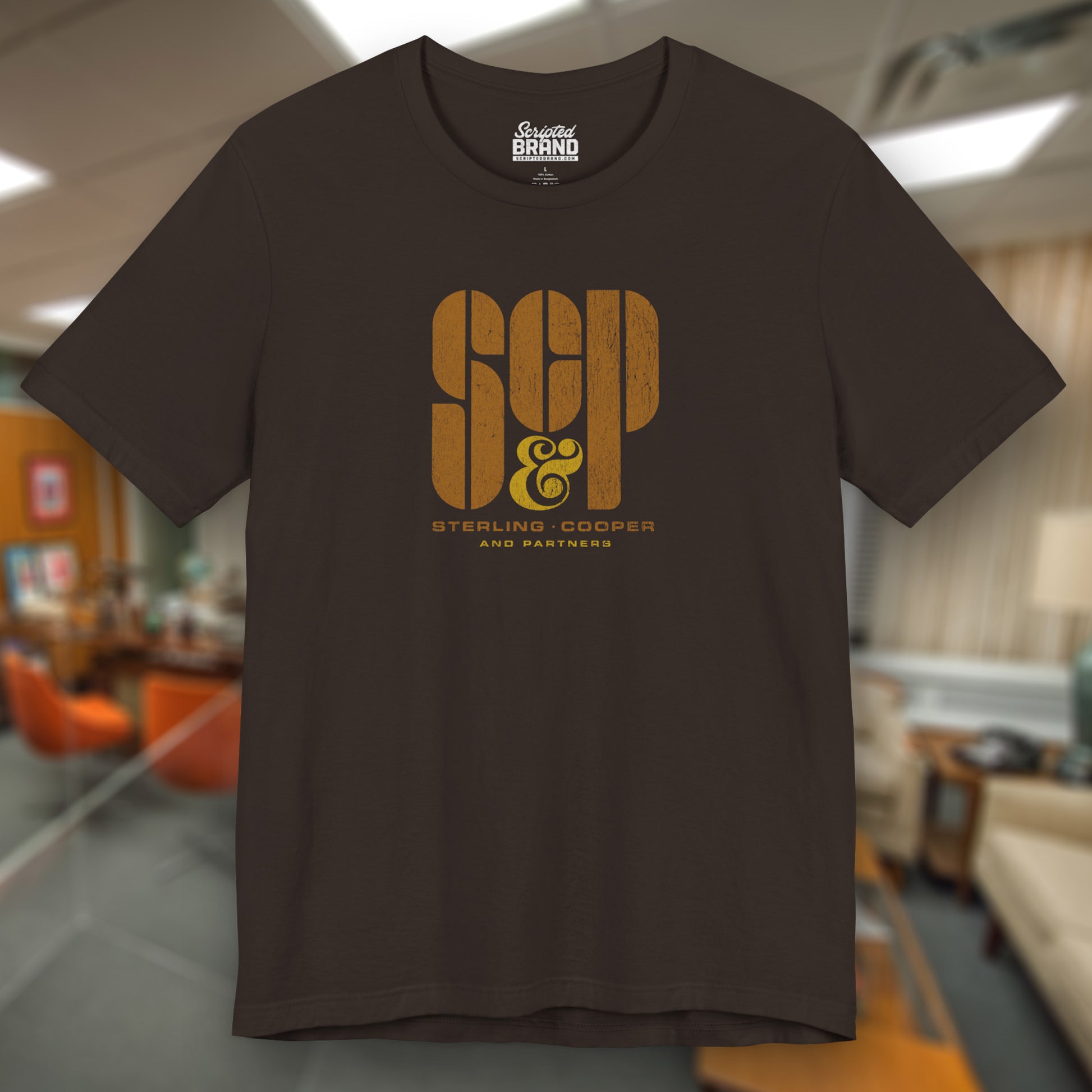 Front view of a brown colored soft unisex Bella+Canvas 3001 short-sleeve t-shirt featuring the Sterling Cooper & Partners logo graphic from the TV Show Mad Men in a vintage distressed style, sold by ScriptedBrand.