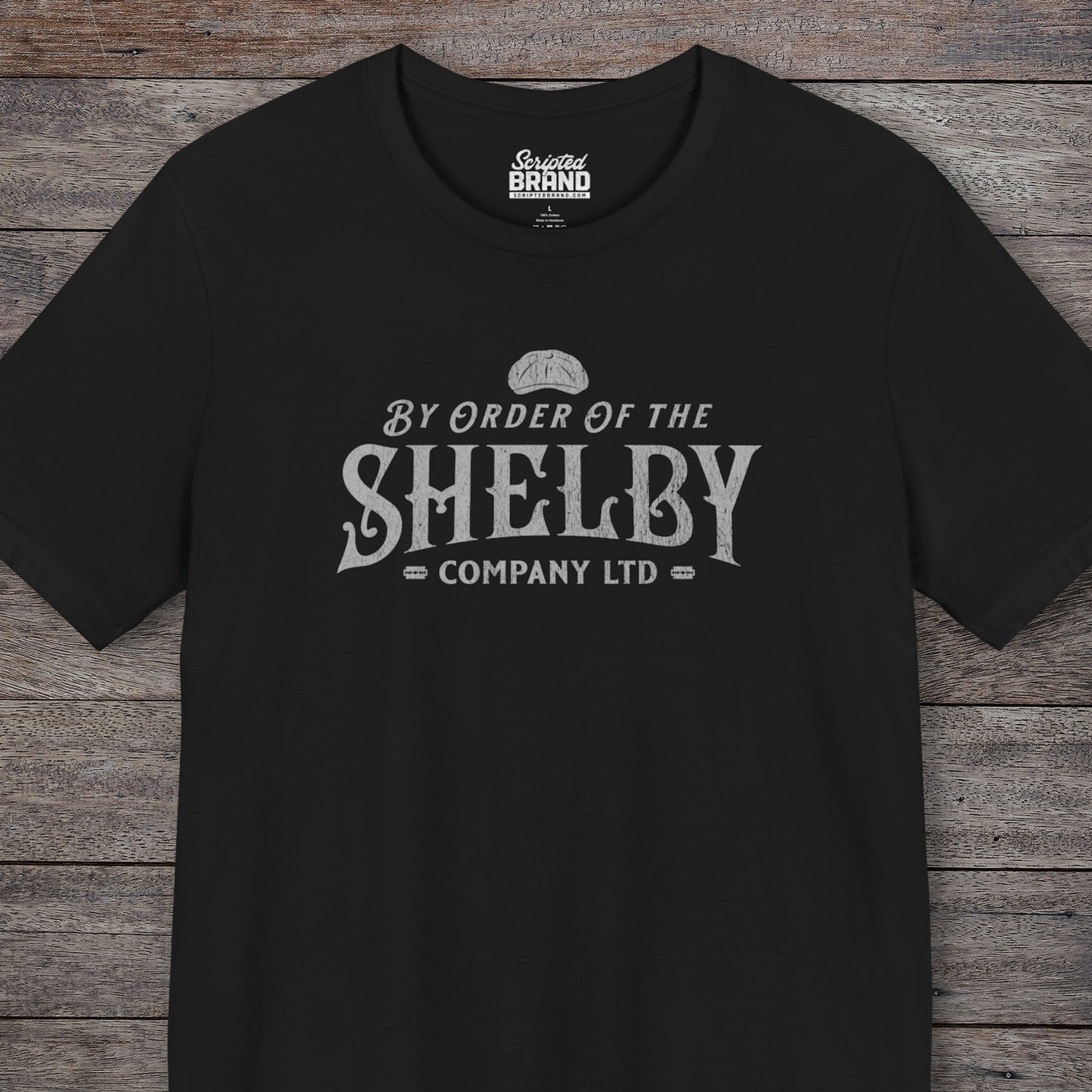 Front view of a black colored soft short-sleeve Bella+Canvas 3001 t-shirt featuring a unique Shelby Company Limited logo graphic from the show Peaky Blinders and movie The Immortal Man, in a vintage distressed style, includes a flat cap and razor blades, designed and sold by ScriptedBrand.