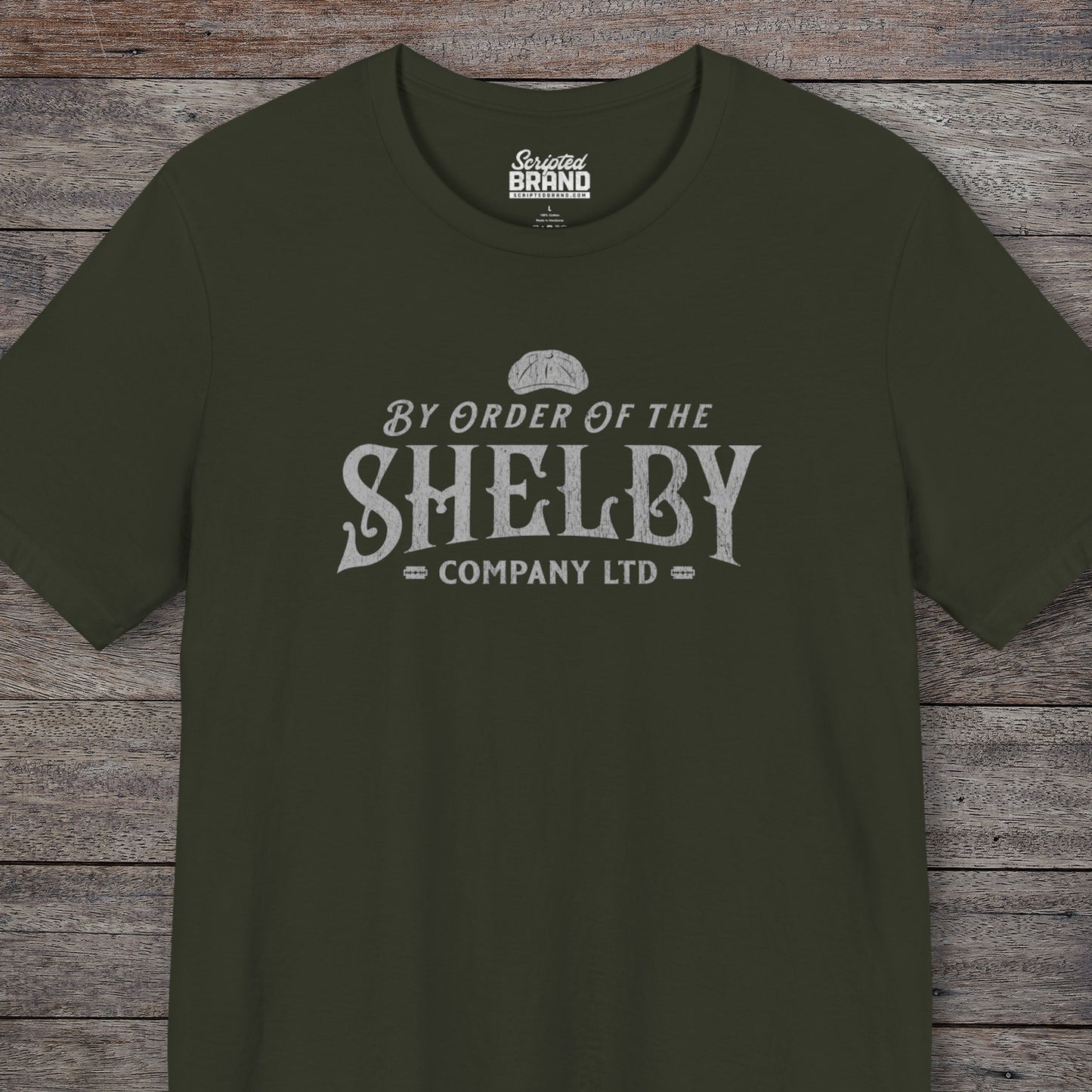 Front view of a dark olive colored soft short-sleeve Bella+Canvas 3001 t-shirt featuring a unique Shelby Company Limited logo graphic from the show Peaky Blinders and movie The Immortal Man, in a vintage distressed style, includes a flat cap and razor blades, designed and sold by ScriptedBrand.