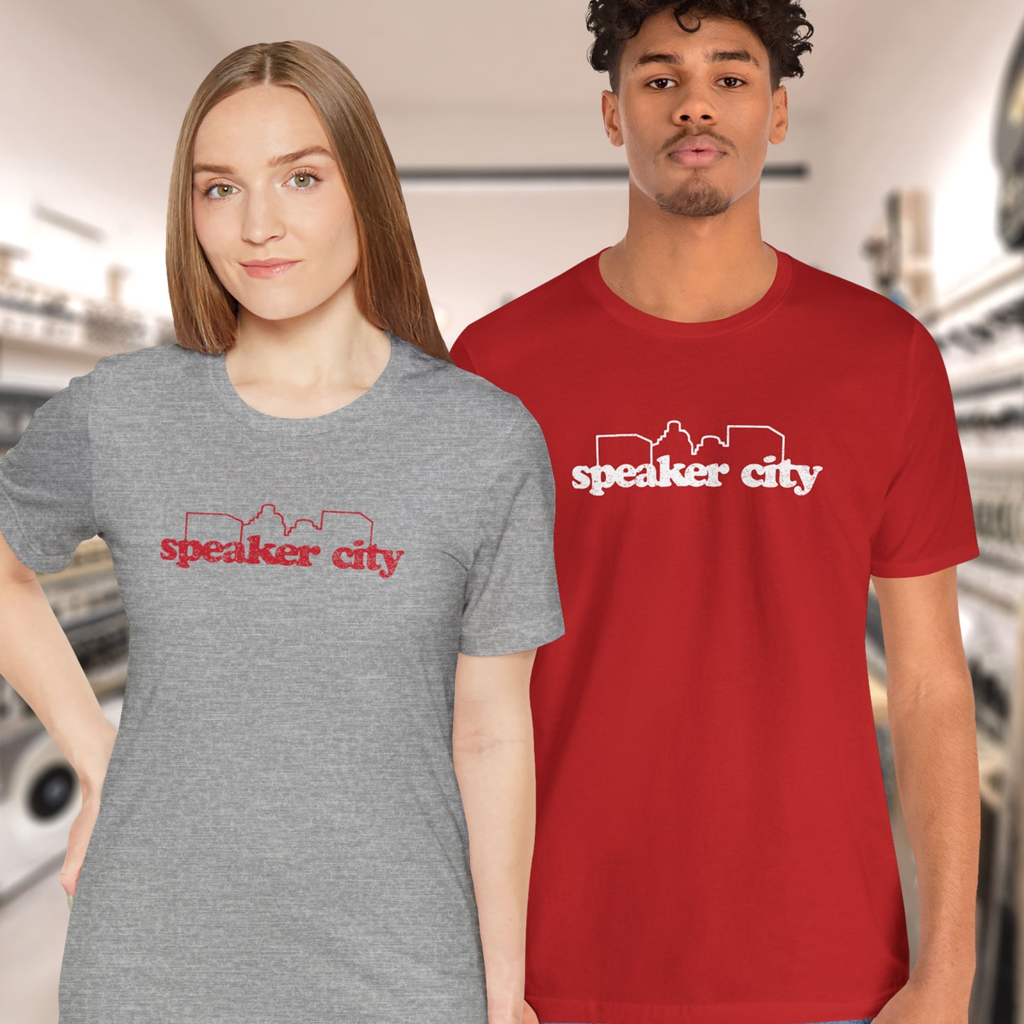 2 models wearing t-shirts featuring the Speaker City logo from the movie Old School in a vintage distressed style and skyline outline.