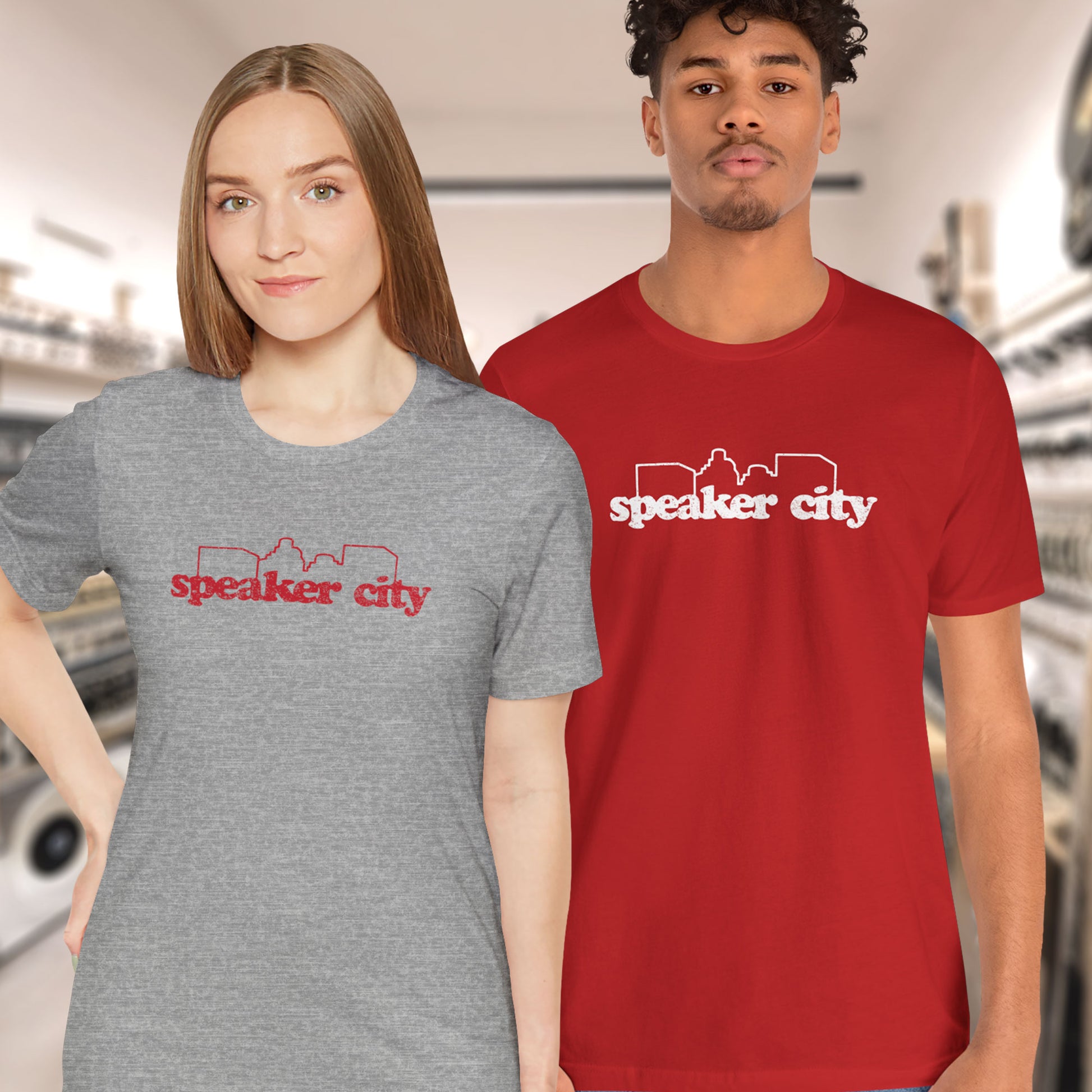 2 models wearing t-shirts featuring the Speaker City logo from the movie Old School in a vintage distressed style and skyline outline.
