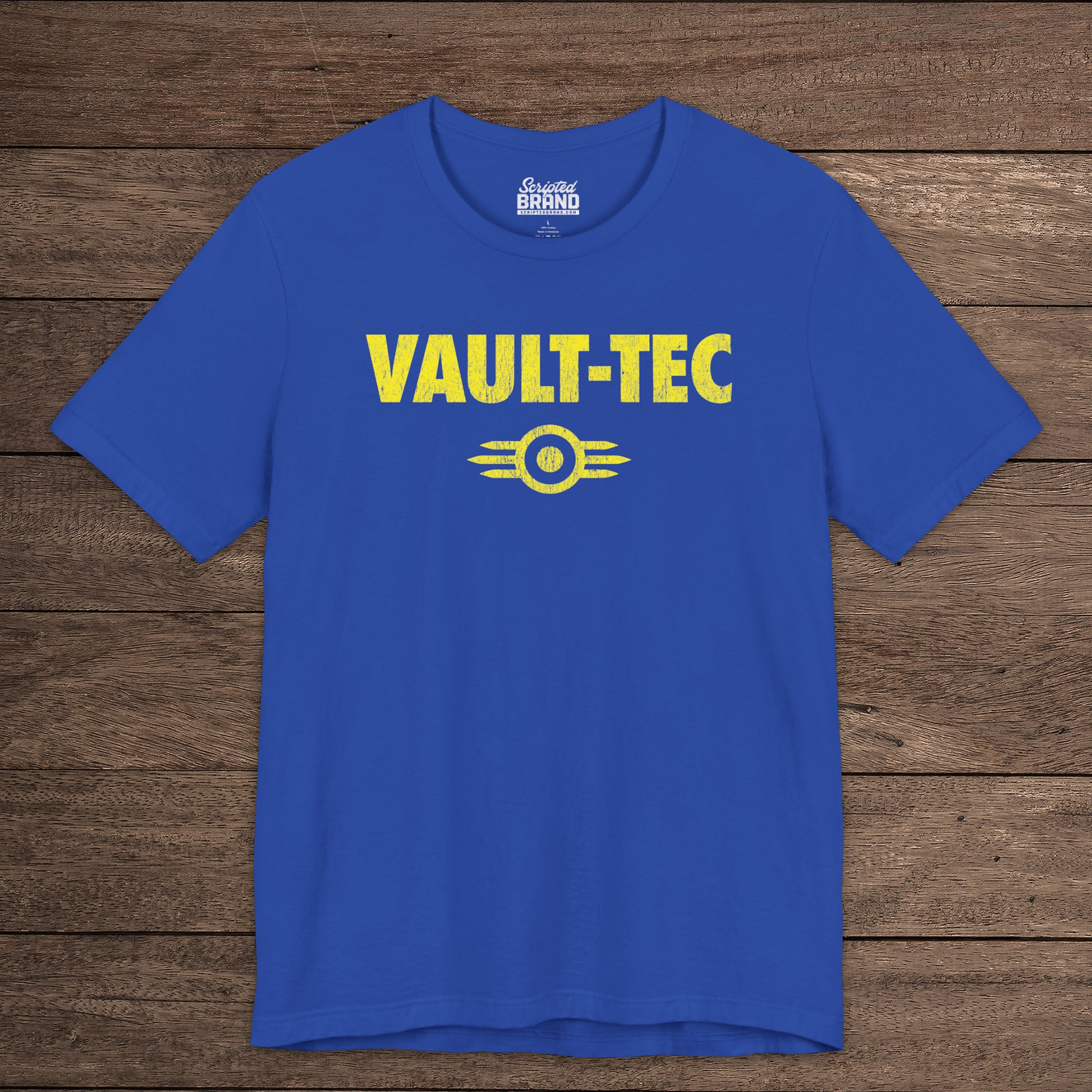 Royal blue t-shirt featuring the Vault-Tec logo graphic from the video game Fallout in a vintage distressed style. 