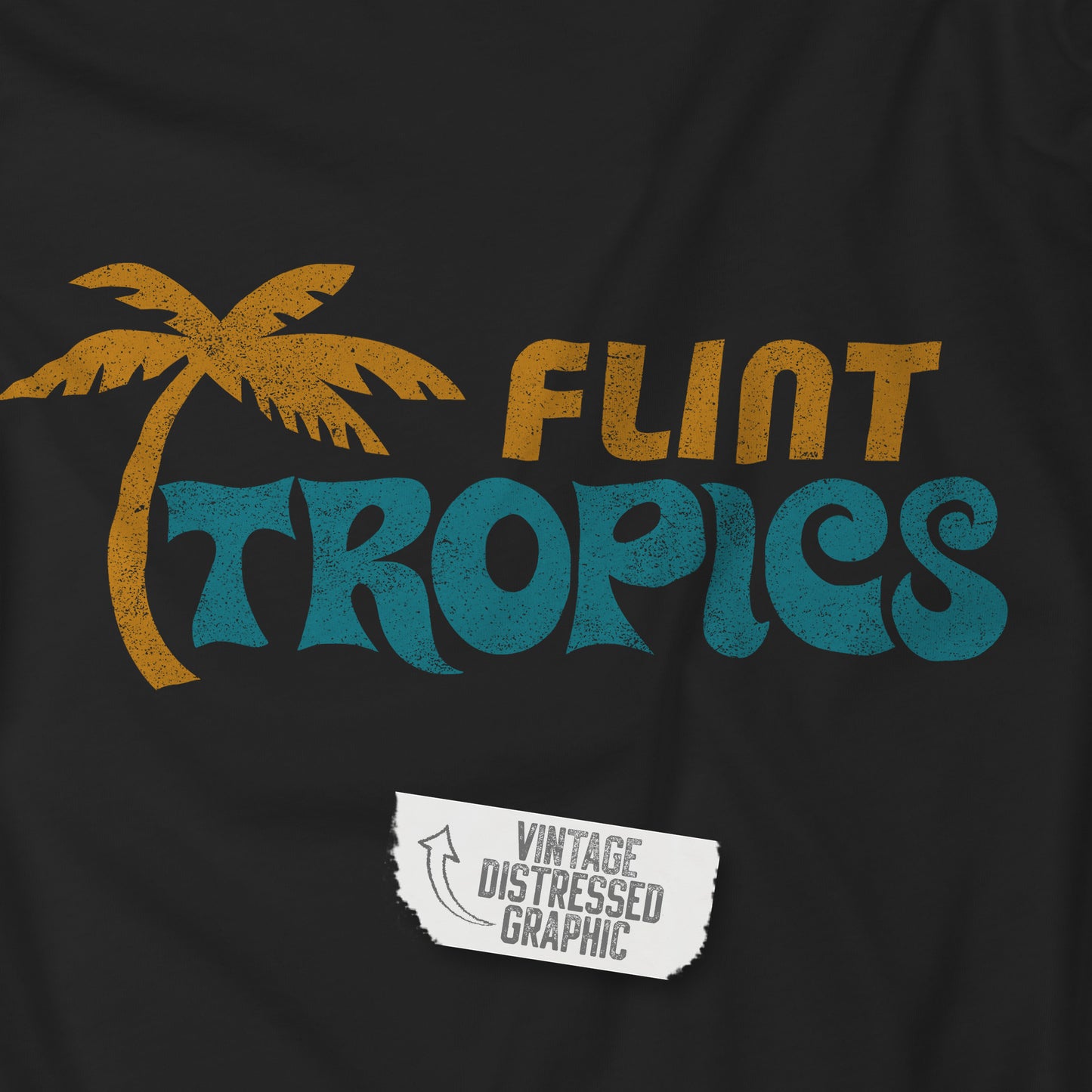 Coseup view of a black soft Bella+Canvas 3001 short-sleeve t-shirts featuring the Flint Tropics logo from the movie Semi-Pro, in a vintage distressed style, sold by ScriptedBrand.