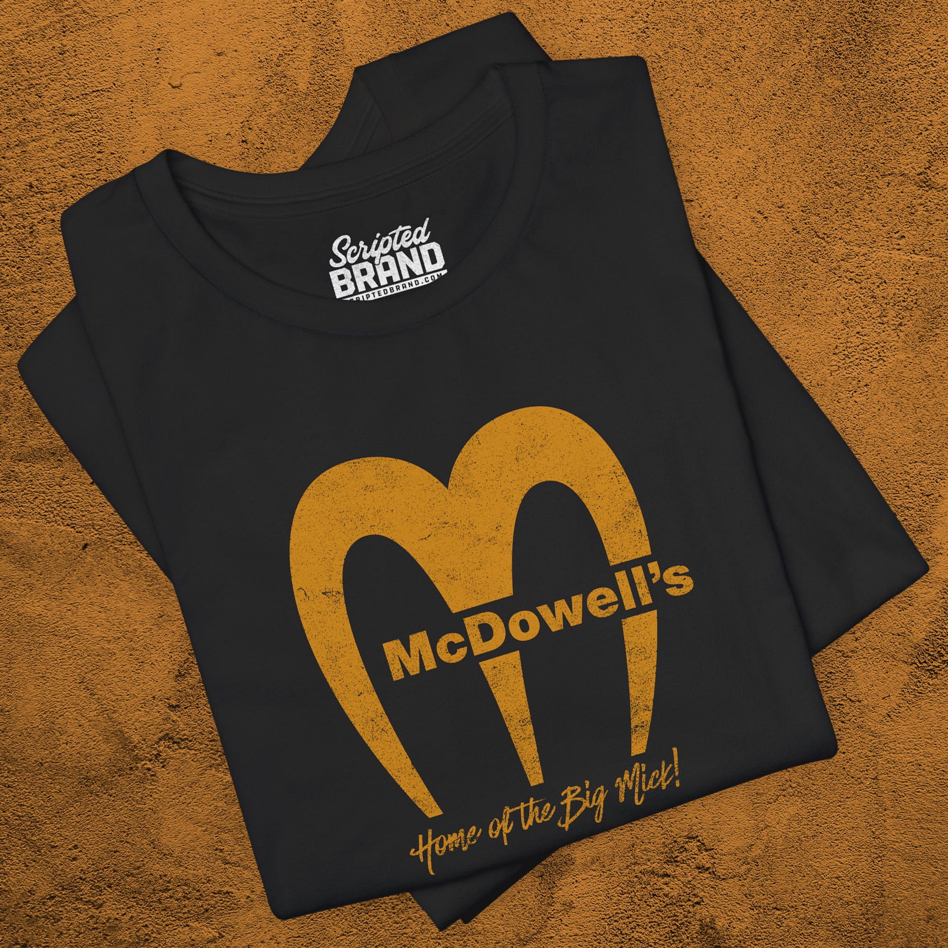 Black t-shirt featuring the McDowells logo from the movie Coming to America in a vintage distressed style.