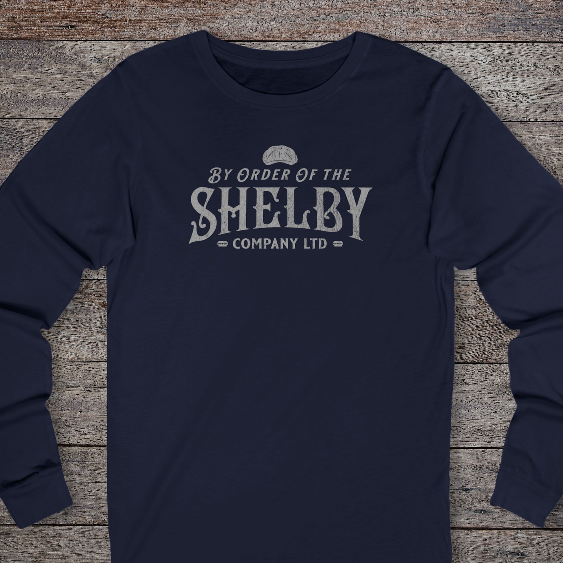 Front view of a navy blue Shelby Company Ltd long-sleeve tee with vintage logo from Peaky Blinders, featuring flat cap and razor blades.