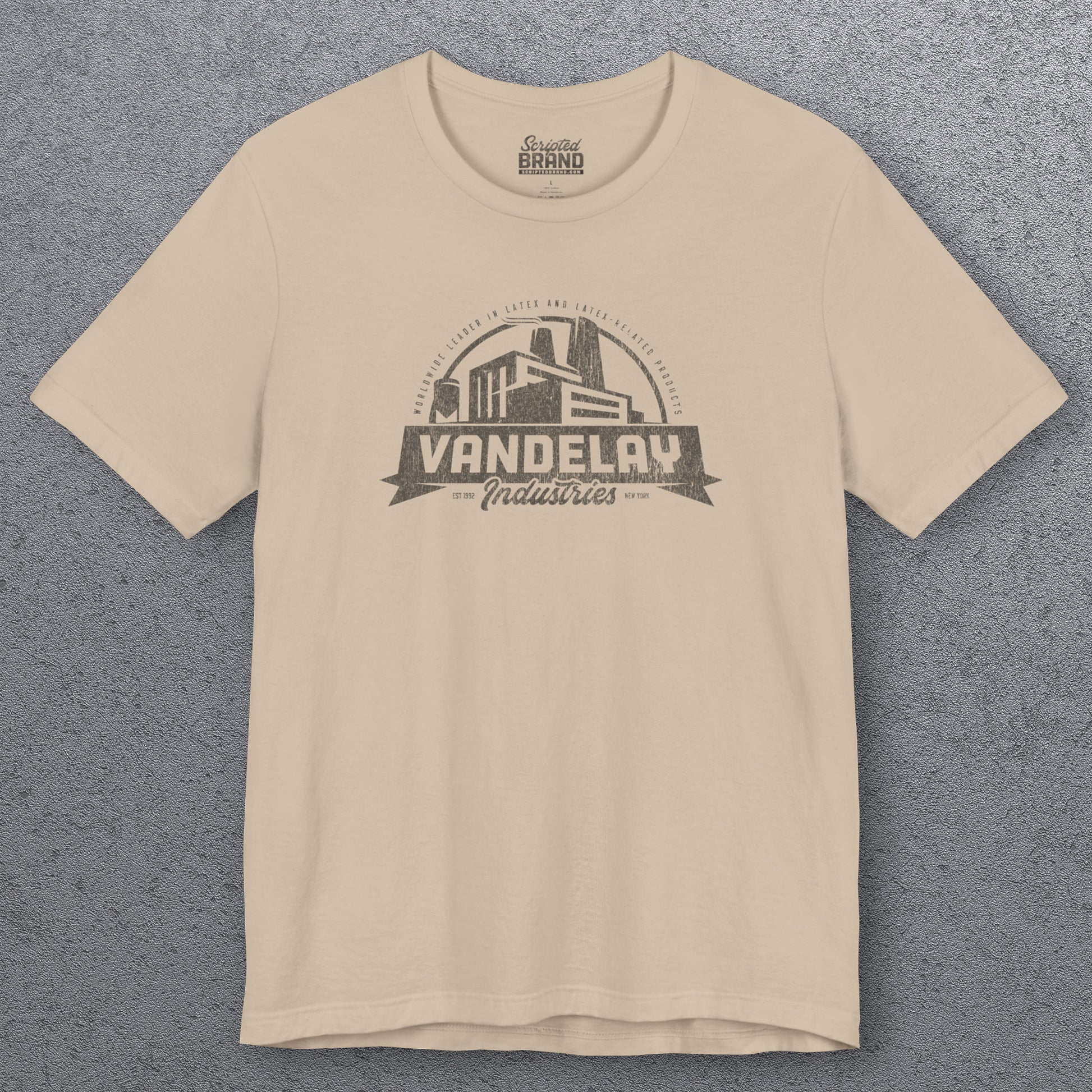 Front view of a tan Soft Bella+Canvas 3001 short-sleeve t-shirt tee featuring a Vandelay Industries logo graphic, uniquely designed by ScriptedBrand in a vintage distressed style. The fictional company is part of the George Costanza storyline in the TV show Seinfeld. 