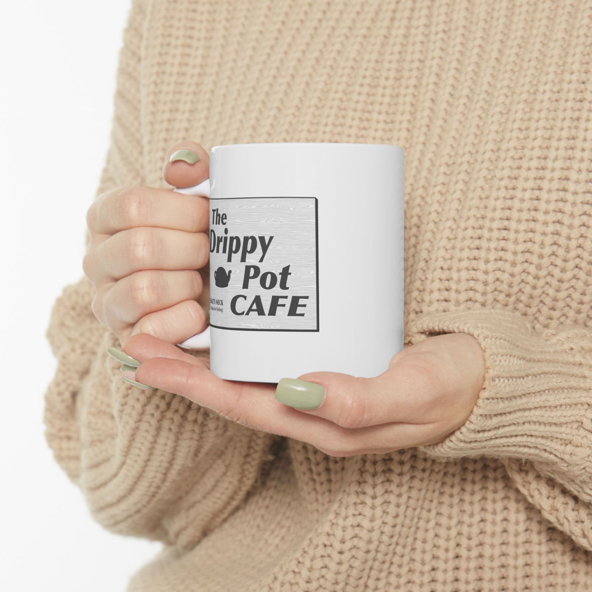 model holding 11 oz White Ceramic Mug with the Drippy Pot Cafe logo graphic from the TV show Severance printed on both sides