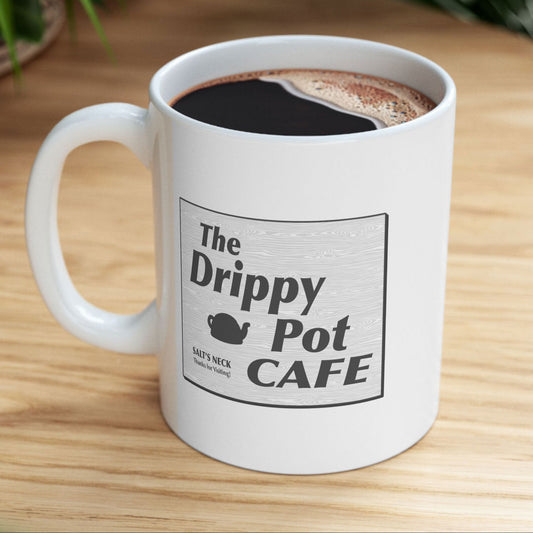 Coffee-filled 11 oz White Ceramic Mug with the Drippy Pot Cafe logo graphic from the TV show Severance printed on both sides.