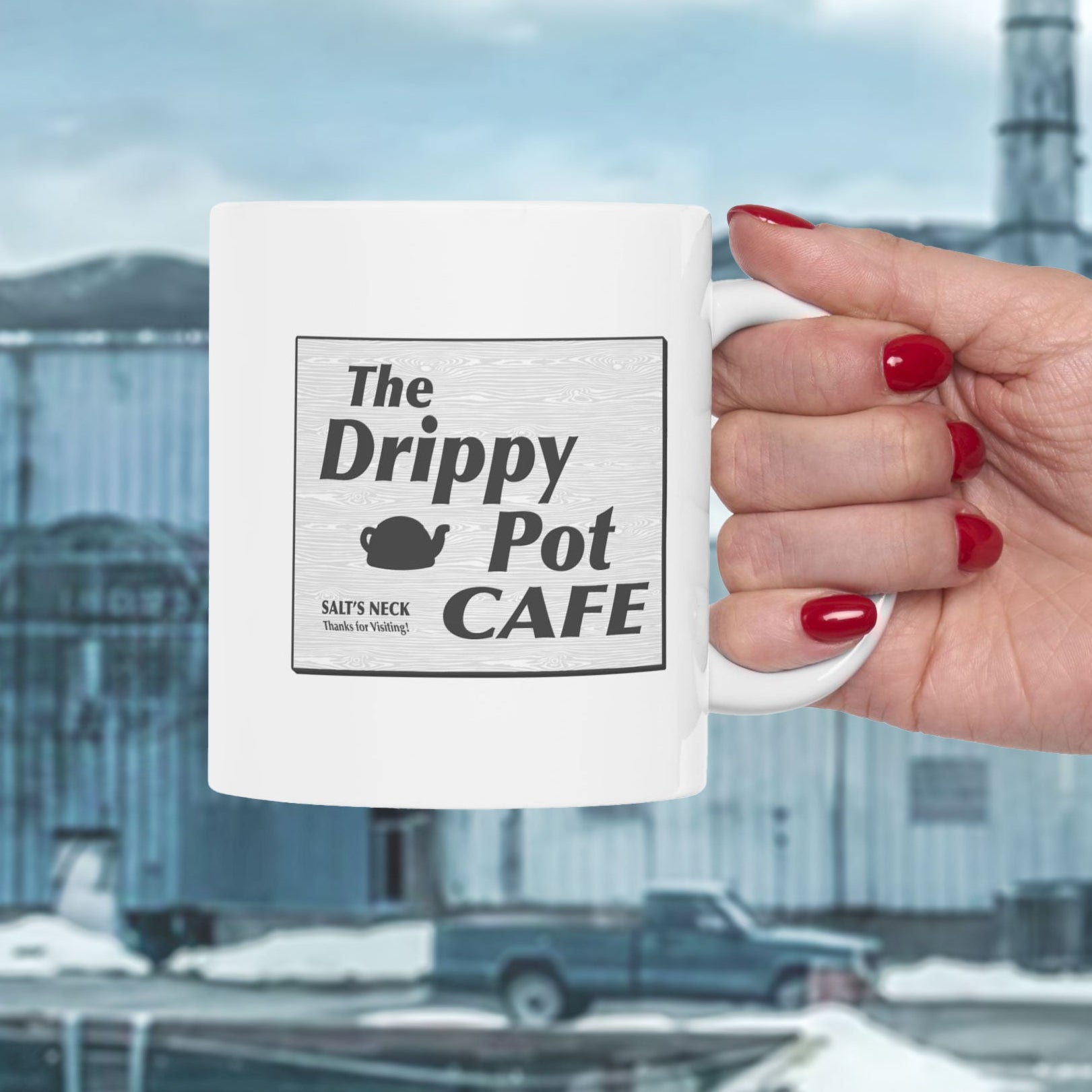 hand holding 11 oz White Ceramic Mug with the Drippy Pot Cafe logo graphic from the TV show Severance printed on both sides