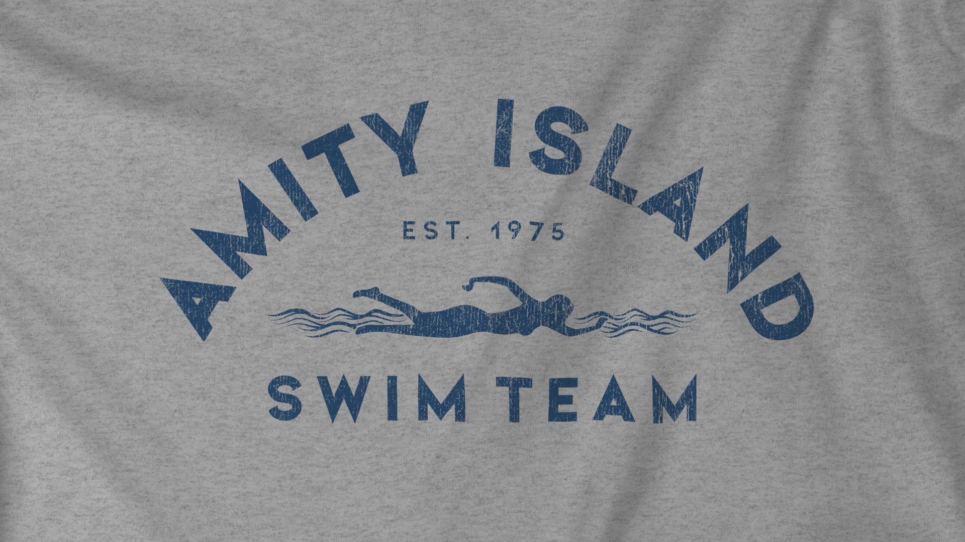 Video closeup of a Soft unisex Youth Sizes Bella+Canvas 3001Y short-sleeve t-shirts featuring an Amity Island Swim Team logo graphic, designed by ScriptedBrand, and  inspired by the movie Jaws in a vintage distressed style.