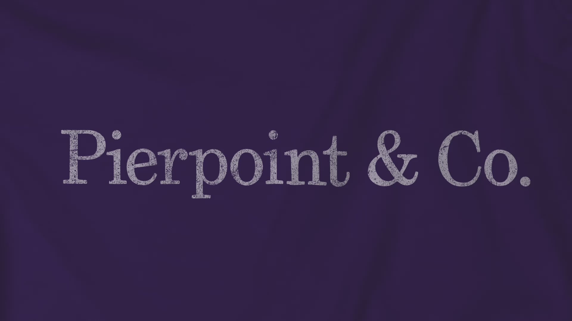 Video closeup of a purple soft short-sleeve Bella+Canvas 3001 t-shirt featuring the fictional logo Pierpoint & Co from the HBO TV show Industry in a vintage distressed style, sold by ScriptedBrand.