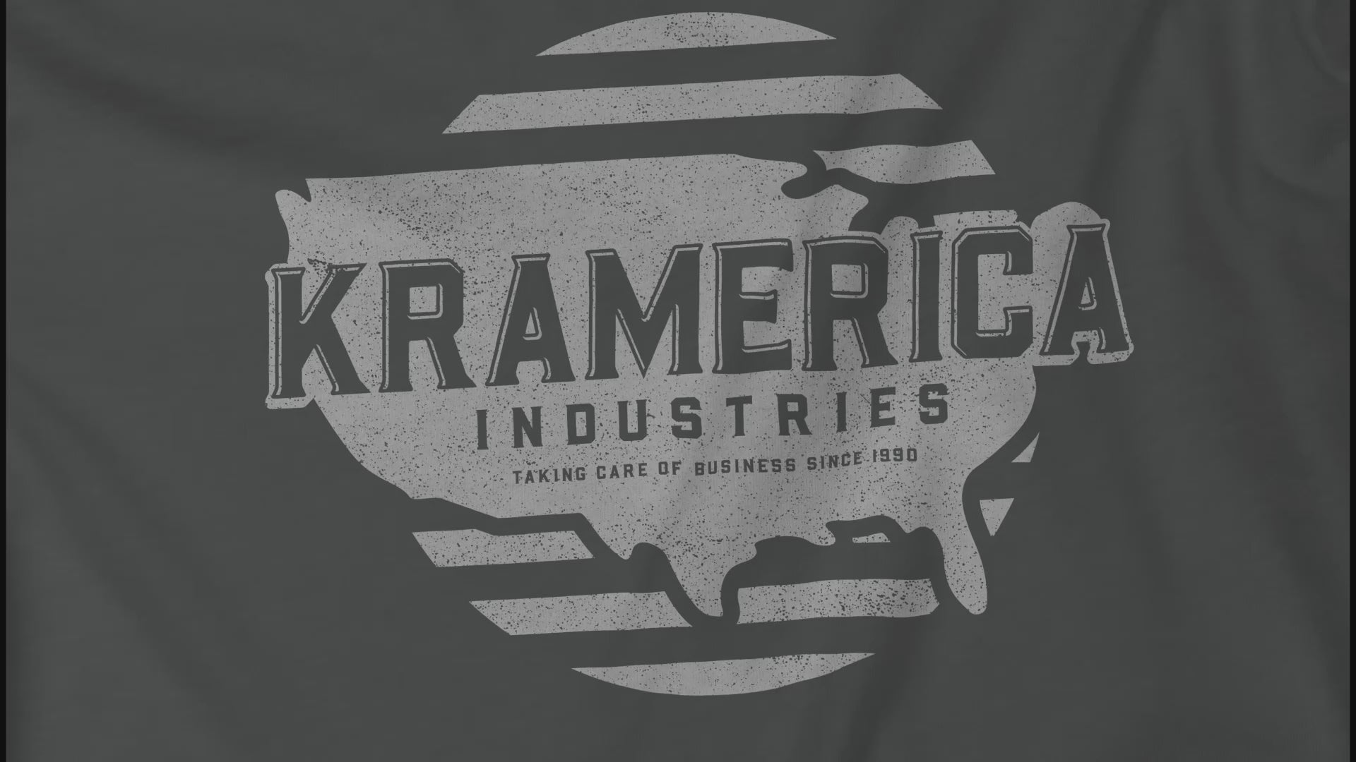 Closeup video of an asphalt grey soft unisex Bella+Canvas 3001 short-sleeve t-shirt featuring a unique Kramerica Industries logo graphic, designed by ScriptedBrand in a vintage distressed style, and inspired by the TV show Seinfeld.