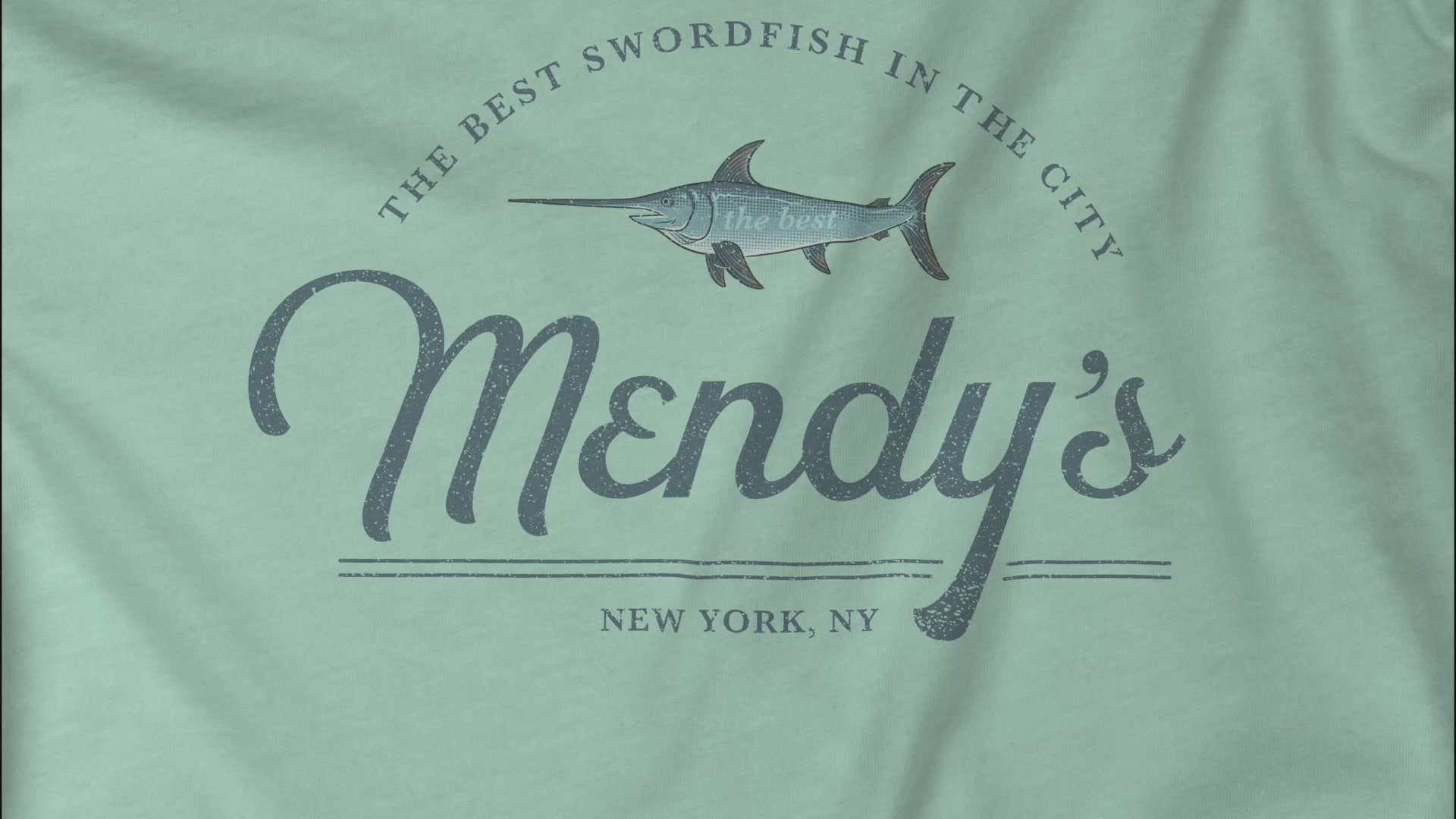 Video closeup of soft unisex Bella+Canvas 3001 short-sleeve t-shirts featuring a unique Mendy's Restaurant logo graphic, designed by ScriptedBrand in a vintage distressed style, and inspired by the TV show Seinfeld.
